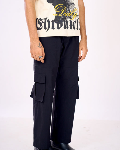 Person wearing black cargo pants with a white background
